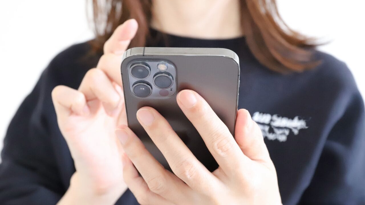 スマートフォンで問い合わせる女性